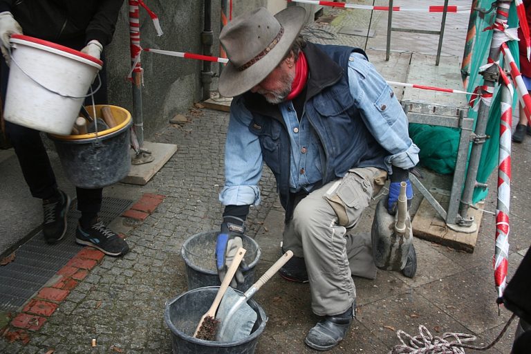 Kniend mit Zementeimer