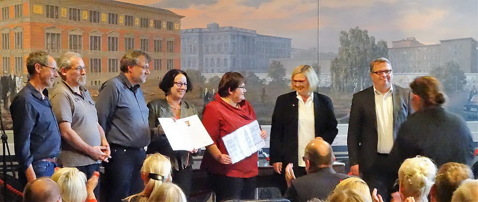 Der Arbeitskreis erhält Förderpreis. Vor der bemalten Wand im Goldenen Saal im Rathaus Schöneberg