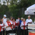 Chor: Männer und Frauen mit roten Schals