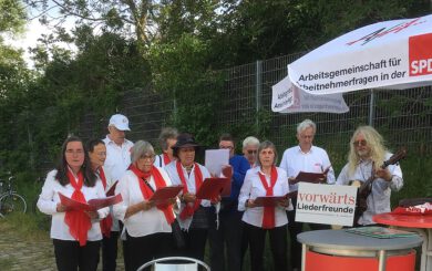 Chor: Männer und Frauen mit roten Schals