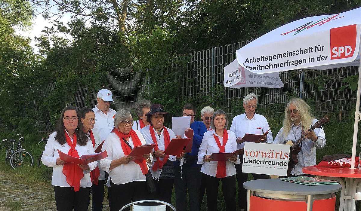 Chor: Männer und Frauen mit roten Schals