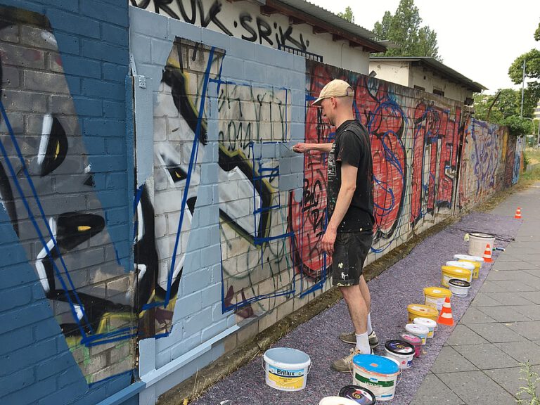 Mann beim Bemalen der Außenmauer